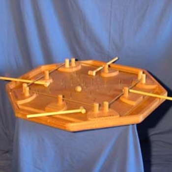 Les Marteaux - 
But : Equipé d'un petit marteau de bois, il faut repousser une bille en métal vers une des deux cavités des adversaires tout en se défendant.