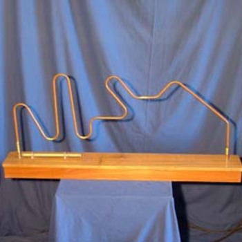 Spirale électrique - 
But : Le joueur tient, au bout d’un manche, un anneau. L’anneau doit coulisser dans la spirale sans toucher celle-ci sinon ça sonne et on recommence